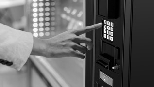 hand select a product in a vending machine
